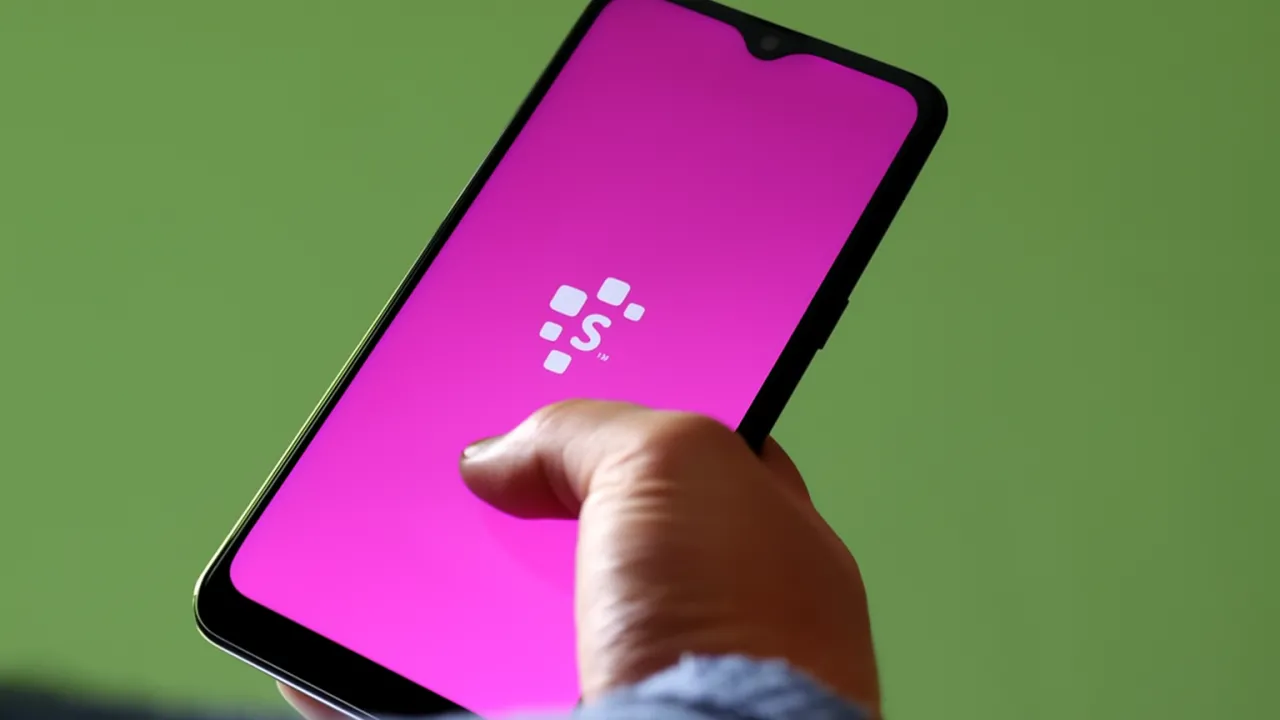Homem acessando o aplicativo do Serasa pelo celular e descobrindo um a negativação indevida.