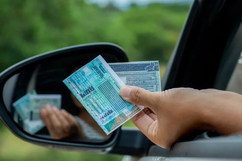 Motorista entregando documento através da janela do carro e descobrindo a suspensão da CNH.