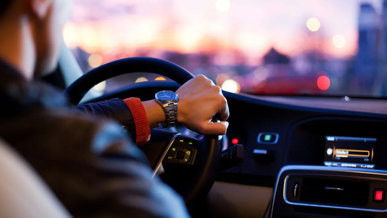Motorista dirigindo preocupado com o licenciamento vencido do veículo.
